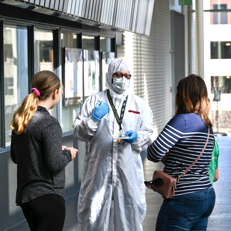 A group of secondary students talks to a Georgia Tech researcher before beginning a tour of the cleanroom. 