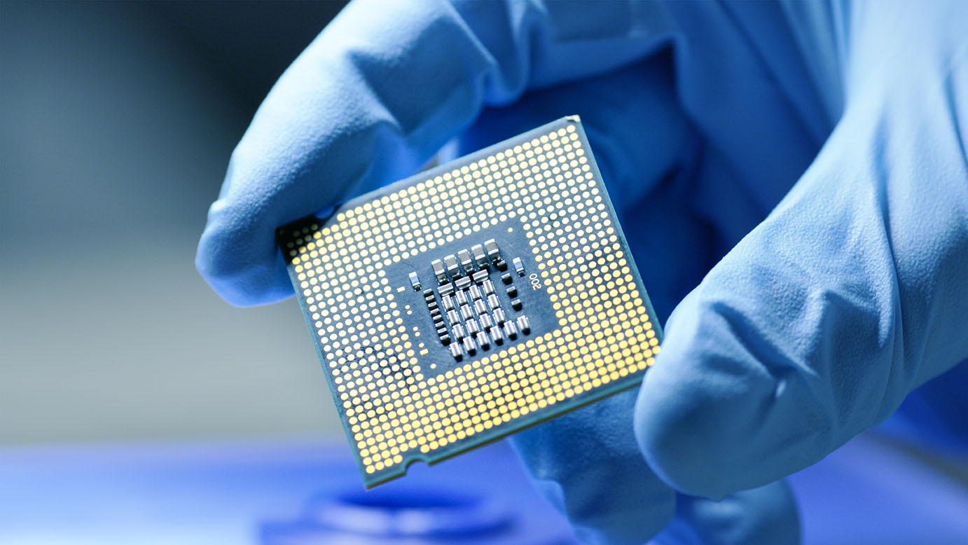 Gloved hand holds semiconductor chip