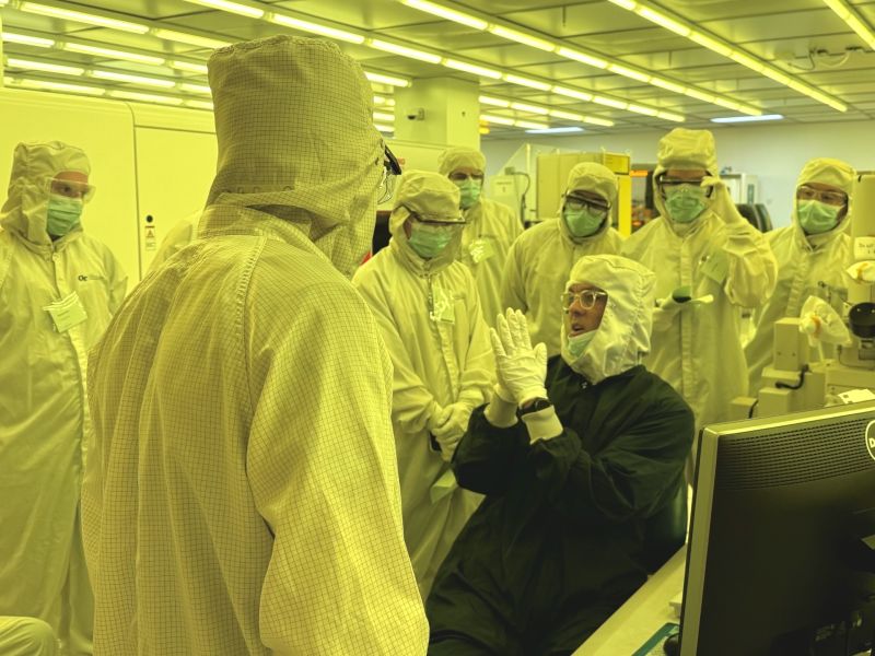 Instructor in cleanroom attire teaches a short course to students in the IMS cleanroom