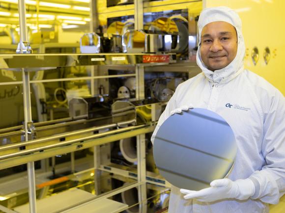 Asif Khan holds a silicon wafer in a cleanroom.