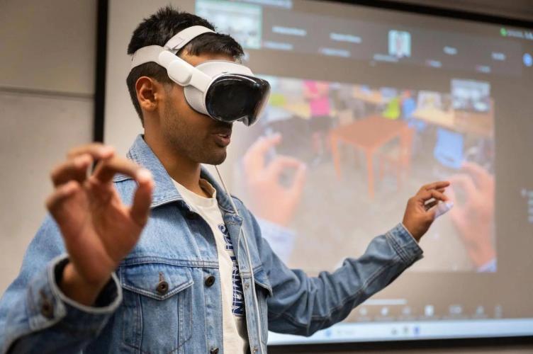 Georgia Tech student Yash Rajgure using an Apple Vision Pro headset device to demo his team's project.