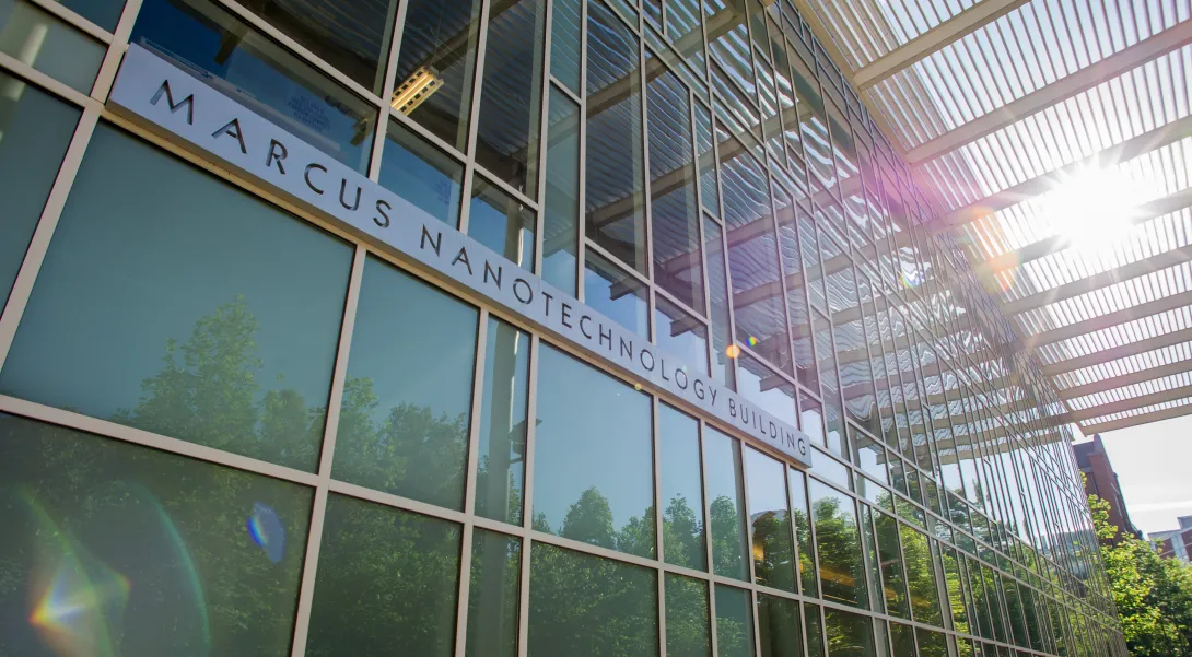 Photo of the Marcus Nanotechnology Building. A glass building with sunshine shining through in the top right corner. 