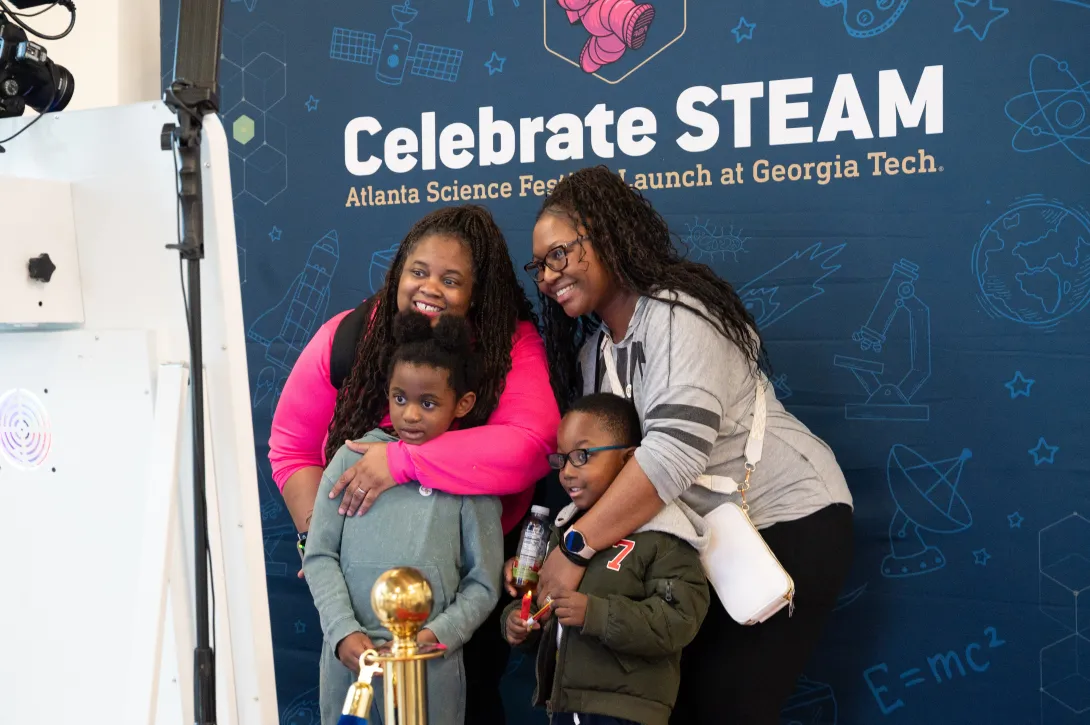 A family poses for a special moment in the Celebrate STEAM photo booth during Georgia Tech&#039;s Celebrate STEAM event on March 8.